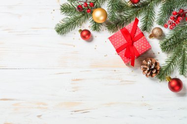Kırmızı kurdeleli ve Noel süslemeli Noel hediyesi kutusu.
