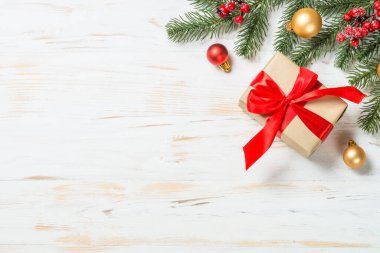 Kırmızı kurdeleli ve Noel süslemeli Noel hediyesi kutusu.