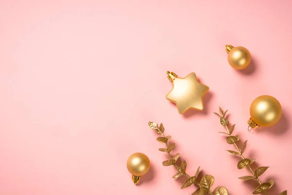 Composición navideña con decoraciones navideñas doradas en fondo rosa. —  Fotos de Stock