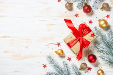 Kırmızı kurdeleli ve Noel süslemeli Noel hediyesi kutusu.
