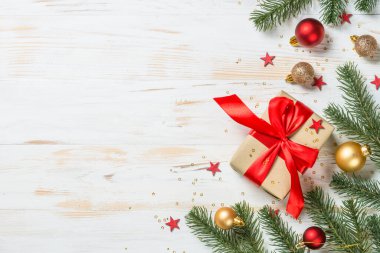 Kırmızı kurdeleli ve Noel süslemeli Noel hediyesi kutusu.