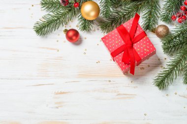 Kırmızı kurdeleli ve Noel süslemeli Noel hediyesi kutusu.