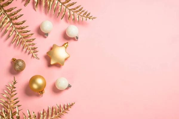 Composição de Natal com decorações de Natal dourado em fundo rosa. — Fotografia de Stock