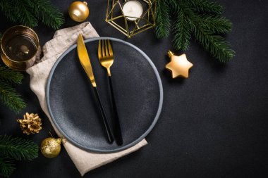 Siyah arka planda tatil süslemeleri olan Noel sofrası.