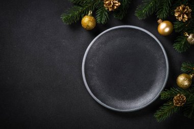 Siyah arka planda tatil süslemeleri olan Noel sofrası.
