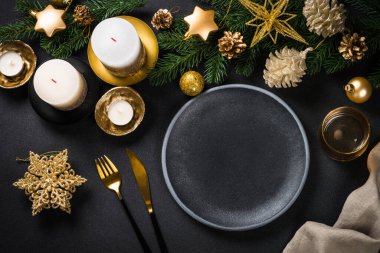 Siyah arka planda tatil süslemeleri olan Noel sofrası.