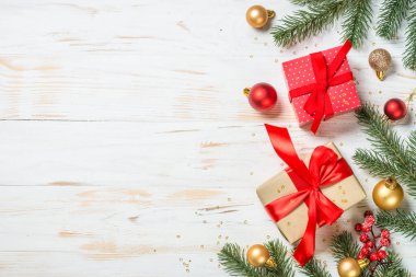 Kırmızı kurdeleli ve Noel süslemeli Noel hediyesi kutusu.