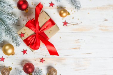 Kırmızı kurdeleli ve Noel süslemeli Noel hediyesi kutusu.