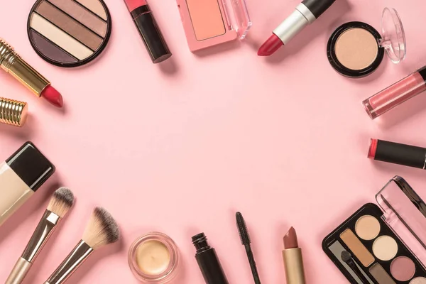 Maquiagem produtos no fundo rosa vista superior. — Fotografia de Stock