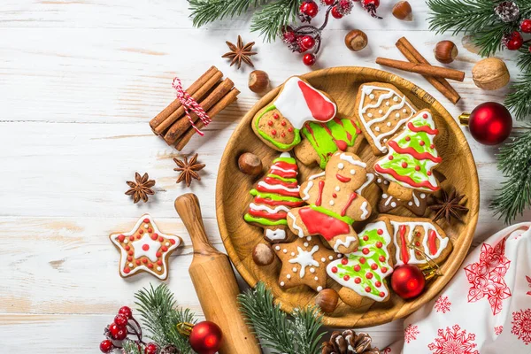 Julpepparkakor i tallriken med kryddor och dekorationer på vitt träbord. — Stockfoto
