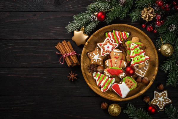 Pão de gengibre de Natal na placa com especiarias e decorações na mesa de madeira escura. — Fotografia de Stock