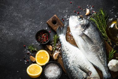 Siyah taş masada taze balık dorado..