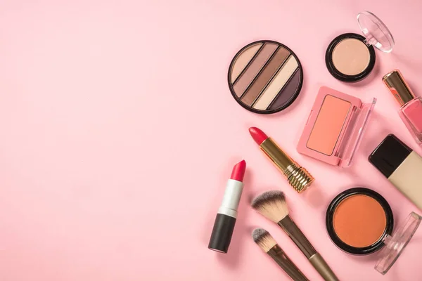 Maquiagem produtos no fundo rosa vista superior. — Fotografia de Stock