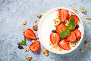 Mısır gevrekli yoğurt ve beyaz kasede çilek.