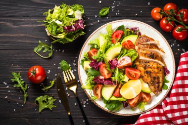 Ahşap masada taze salata ve ızgara tavuk..