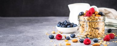 Cam kavanozda taze böğürtlenli granola.