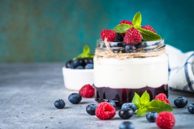 Kremalı parfüm ve cam kavanozda taze böğürtlen.