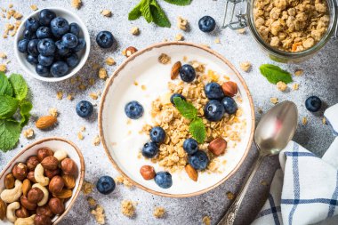 Taş masada taze yaban mersinli yoğurt taneleri..