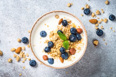 Taş masada taze yaban mersinli yoğurt taneleri..