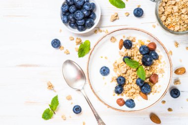 Beyaz ahşap masada taze yaban mersinli yoğurt taneciği..