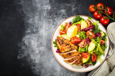 Ahşap masada taze salata ve ızgara tavuk..