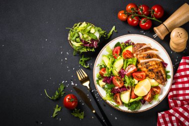 Siyah masada taze salata ve ızgara tavuk..