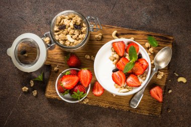 Mısır gevrekli yoğurt ve beyaz kasede çilek.