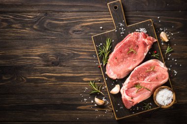 Tahta masada taze biftek ve baharat var..