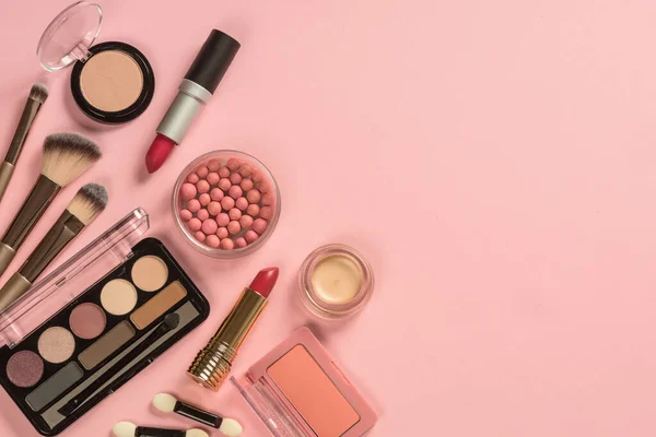 Maquillaje productos en rosa vista superior de fondo. — Foto de Stock