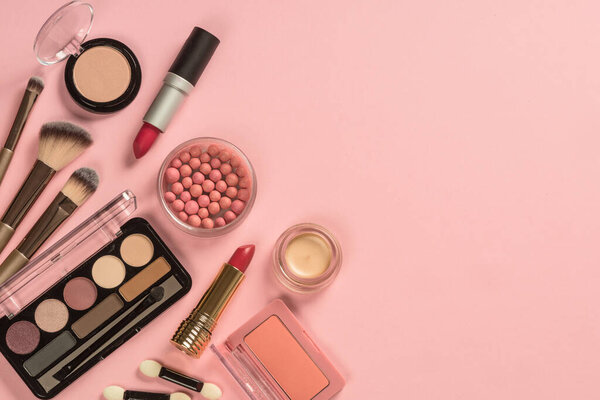Make up products at pink background top view.