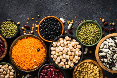 Baklagil, mercimek, bezelye ve fasulye çeşitleri siyah taş masada..