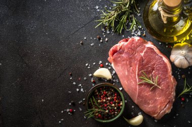 Siyah arka planda baharatlı taze biftek..