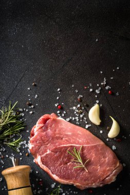 Siyah arka planda baharatlı taze biftek..