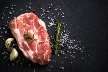 Siyah arka planda baharatlı taze biftek..