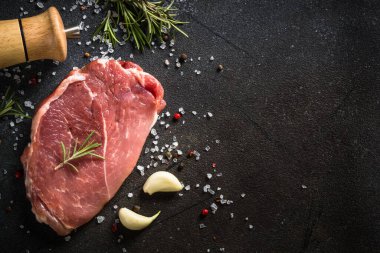 Siyah arka planda baharatlı taze biftek..