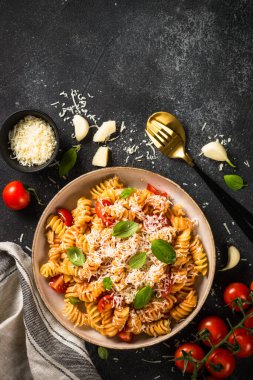 İtalyan makarnası alla arrabiata fesleğen ve parmesan peyniri ile koyu masa..