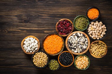 Baklagil, mercimek, bezelye ve fasulye çeşitleri siyah taş masada..