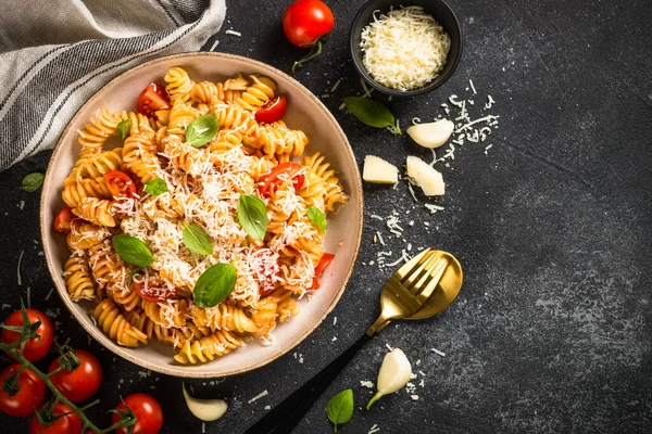 İtalyan makarnası alla arrabiata fesleğen ve parmesan peyniri ile koyu masa.. — Stok fotoğraf