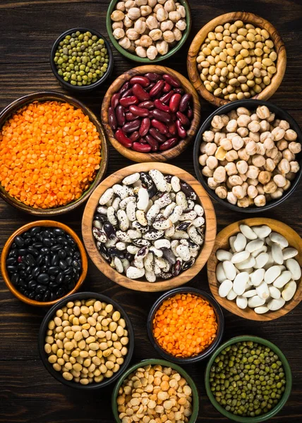 Surtido de legumbres, lentejas, garbanzos y frijoles sobre mesa de piedra negra. —  Fotos de Stock