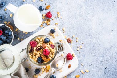 Cam kavanozda taze böğürtlenli granola.