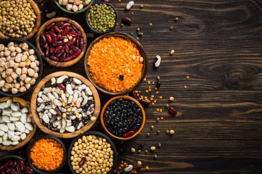 Baklagil, mercimek, bezelye ve fasulye çeşitleri siyah taş masada..