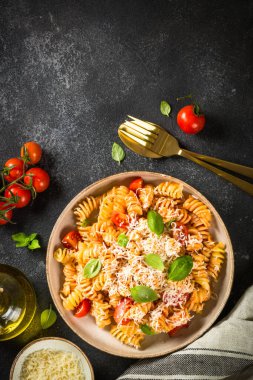 İtalyan makarnası alla arrabiata fesleğen ve parmesan peyniri ile koyu masa..