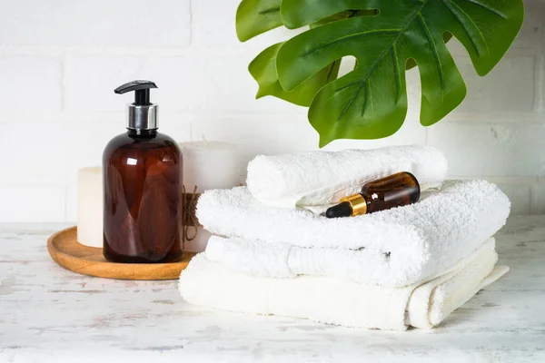 Botella de jabón y pila de toallas en baño blanco. — Foto de Stock