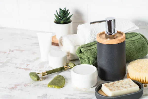 Accesorios de baño. Botella de jabón, crema, suero y toallas — Foto de Stock