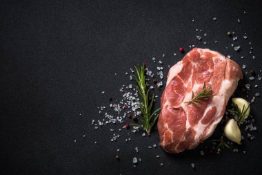 Siyah arka planda baharatlı taze biftek..