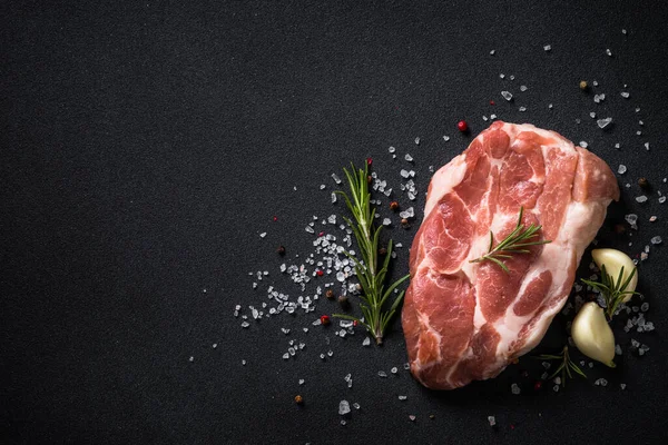 Siyah arka planda baharatlı taze biftek..