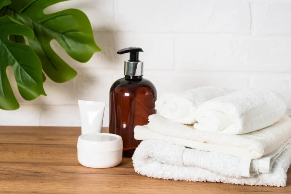 Botella de jabón y pila de toallas en baño blanco. — Foto de Stock
