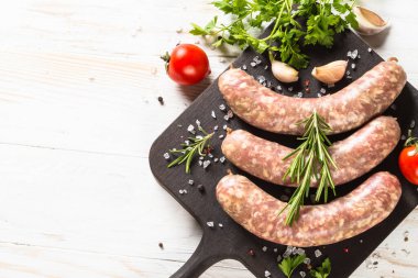 Sosis ya da sosis beyaz ahşap masadaki tahtayı keser..