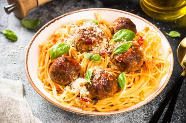 Işık masasında domates soslu köfteli makarna.