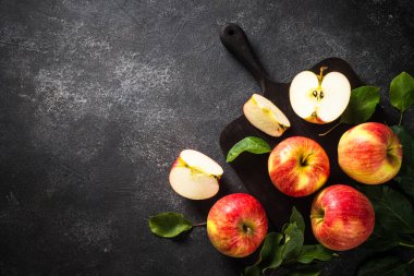 Beyaz masadaki sepetin içinde taze kırmızı elmalar.